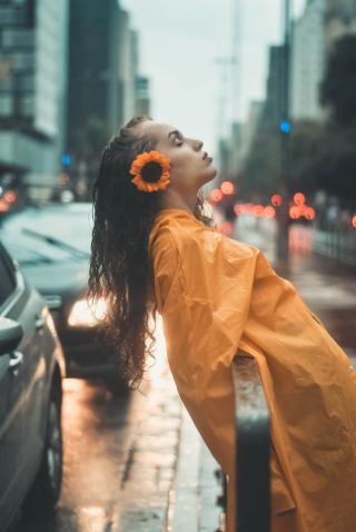 Woman leaning back in rain with her eyes closed Woman leaning back in rain with her eyes closed