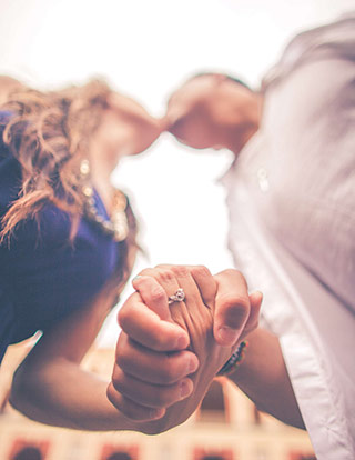 A couple kissing and holding hands, suggesting they can answer, "What does love feel like?"