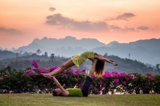 couple doing yoga together on grass