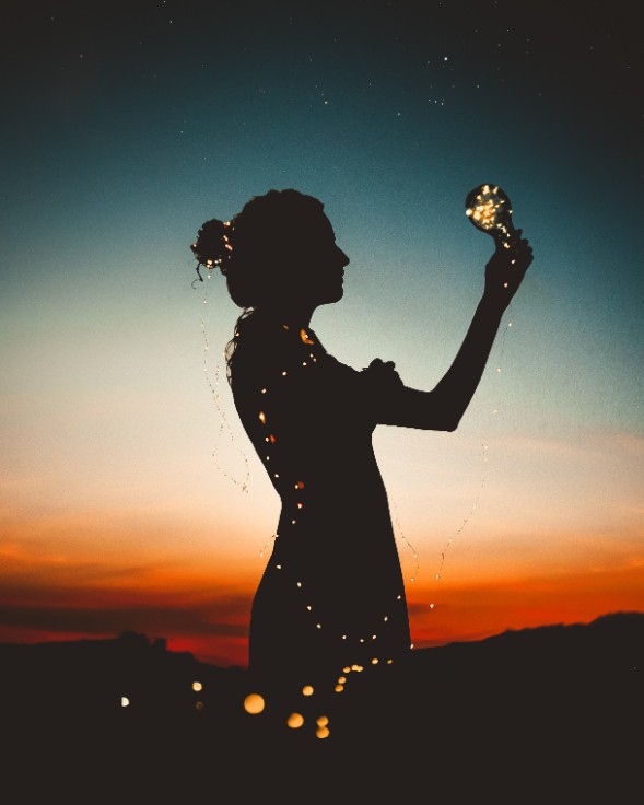 pexels-luizclas-595747 silhouette of woman holding light bulb